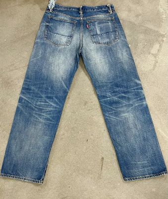 Finition denim lavage léger avec un décoloration subtil et une moustache pour un look classique